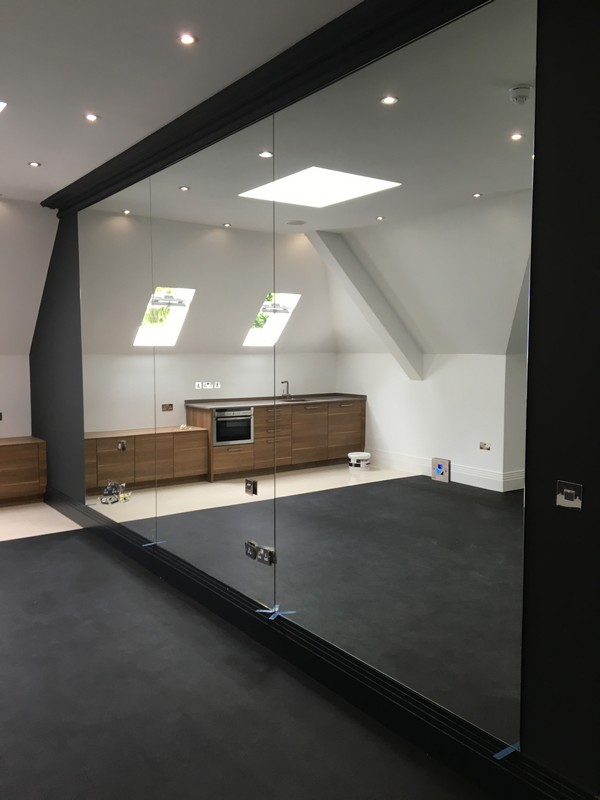 Frameless glass partition in loft conversion by Paddington glaziers